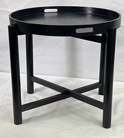 Full view of vintage black folding side table with three legs and removable tray top, showing overall shape and design.