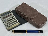 TI-1766 calculator, Pelikan fountain pen and brown leather case shown together