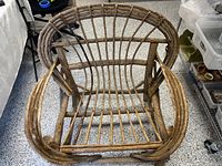 Top view of rustic wooden Adirondack chair showing curved slats forming backrest and seat, with solid armrests and legs.