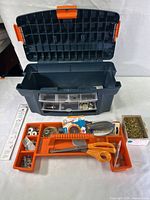 Opened craft box showing empty main storage area and removable plastic storage trays with assorted sewing kit items.