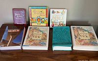 All 8 children's Bibles including various titles and illustrated covers, arranged on a wooden surface.
