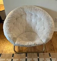 Front view of ivory faux fur Papasan chair showing rounded cushioned seat and backrest with plush texture.