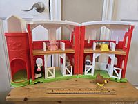 Front view of barn playset with all included animal figurines placed inside and outside the barn