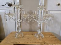 Two heavy vintage crystal candelabras side by side showing overall condition and size with ruler in front.