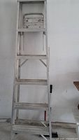 Front view of a 6 ft aluminum step ladder with 5 steps, showing visible wear and dirt on the frame and steps.