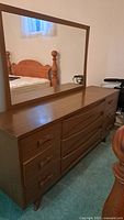 Full view of nine-drawer dresser with attached mirror against wall