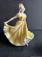 Front-left angle view showing detailed yellow dress, floral patterns, and hand-painted roses in hair