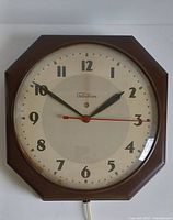 Front view of the vintage Telechron clock showing the full octagonal shape, clock face with numbers, hour, minute, and sweep second hands, and convex glass cover.