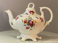 Front and side view showing floral arrangement and spout design