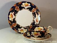 Front view of cake plate, saucer, and cup showcasing pattern and gilding