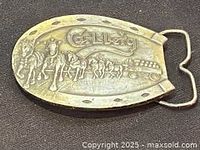 Photo showing the full front of the Carlsberg branded belt buckle with horse-drawn wagon scene.