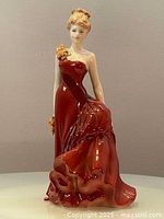 Front view of Coalport porcelain lady figurine in red dress with rose embellishments showing detailed gown and posture.