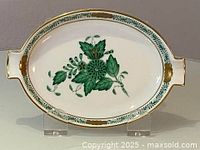 Front view of the Herend porcelain dish showing the oval shape with hand painted green floral design and 24k gold rims and accents.