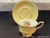 Yellow Paragon porcelain saucer with a ribbed design and gold edge.