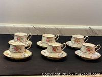 Six Royal Albert teacups paired with matching saucers arranged on a surface, showing front side view