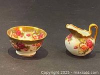 Creamer and sugar bowl with golden rose floral design and gold trim on black background