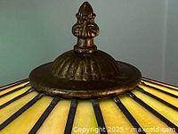Close up of the decorative brass finial and base top on the lamp
