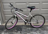 Side view of the silver and pink Ozark Trail girls bike showing overall condition and tires