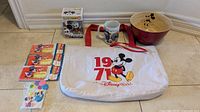 All items shown together including the tote, sealed invitation packs, mixing bowl, mug, Funko Pop figure, and light switch cover.