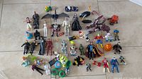 Wide view showing all toys laid out for overview of vintage figures, keychains, and small toys