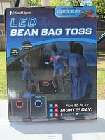 Front view of MinnARK Sports LED Bean Bag Toss game box showing the product image of two light-up boards and instructions about night or day play.