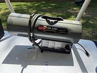 Full view of the Dyna-Glo Delux propane heater with attached cord and hose.