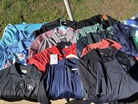Photo showing assortment of men's shirts including polo, button-up, and casual styles in multiple colors and patterns.