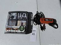 Overview of Black & Decker rotary tool and Dremel accessory kit on a white surface with lot number.