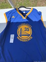 Front view of blue Golden State Warriors sports jersey with number 35 and team logo on front.