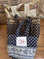 Three Pierre French fabric bags stacked: cream floral, black paisley, and navy paisley patterned bags.