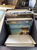 Photo showing a selection of postcards including colorful beach scenes featuring palm trees, beach umbrellas, and sailboats.