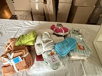 Bundles of small washcloths in various colors displayed on a white surface, some with tags and white straps.