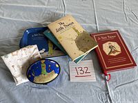 The lot items arranged on a pale blue cloth, showing the beige and red books, two small plates, handkerchief, and blue box tray.