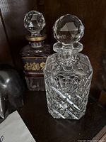 Front and side view of the Val St Lambert clear crystal decanter showing diamond cut detail and faceted stopper.