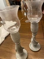 Clear flared glass candle holders with soapstone bases, showing the flared glass top and textured soapstone base with ribbed design, minor wear visible