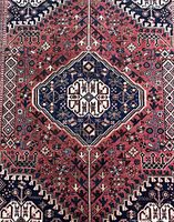 Close-up of central dark blue medallion on red field with surrounding motifs