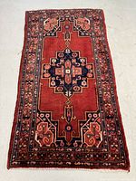 Full view of the rectangular vintage Hamadan rug laid out flat showing deep red color and central medallion