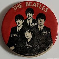 Front side of the red round Beatles pin showing band members and their signatures under "THE BEATLES" text