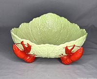 Front angled view showing cabbage leaf texture and one visible lobster foot.