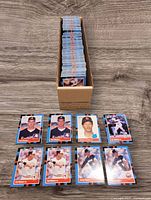 Top view of 1988 Donruss baseball cards stacked in a box, showing the front of various cards including Roberto Alomar rookie, Tom Glavine rookie, Cal Ripken Jr., and Nolan Ryan cards.