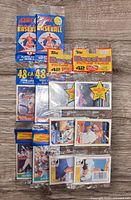 Four sealed 1989 baseball card rack packs: two Score (48 cards each) and two Topps (42 cards each). All in original packaging, showing player images and series branding.