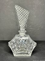 Front view of vintage Art Deco cut glass perfume bottle with diamond-patterned stopper