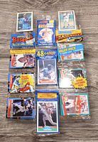 Photo showing arrangement of five sealed vintage baseball rack packs and several loose baseball cards including Bo Jackson and Tony Pena cards, displayed on a white surface.