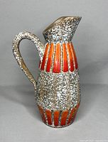 Full side view of the pottery jug showing textured and patterned surface and handle