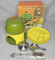 Full view of set with pot, stand, plates, forks, burner, and original box