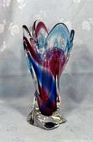 Front view of vintage multicolour swirl art glass vase showing purple and blue swirls in clear glass with wavy rim