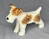 Front and left side view of the Sylvac porcelain dog figurine showing brown and white coloration and textured fur details.