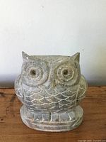 Front view of owl soapstone carving showing detailed eyes, feathers and base with natural stone texture.