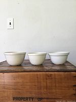 Photo of three white antique pudding bowls side by side, showing their size and shape.