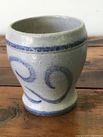 Side view of the cup showing the blue swirl patterns and glaze texture.